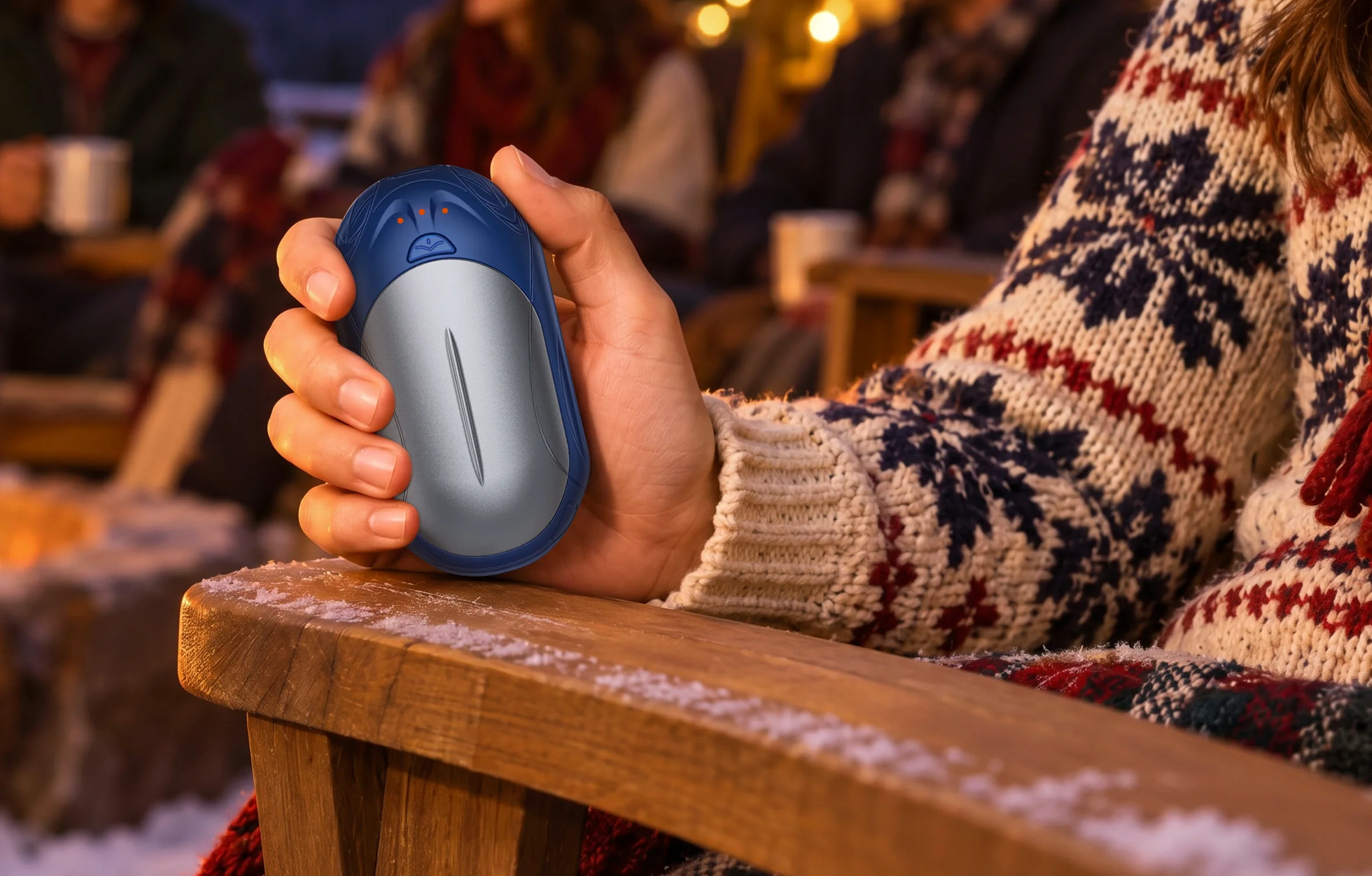 A Blue Grey UNIHAND hand warmer held by an outdoor fire