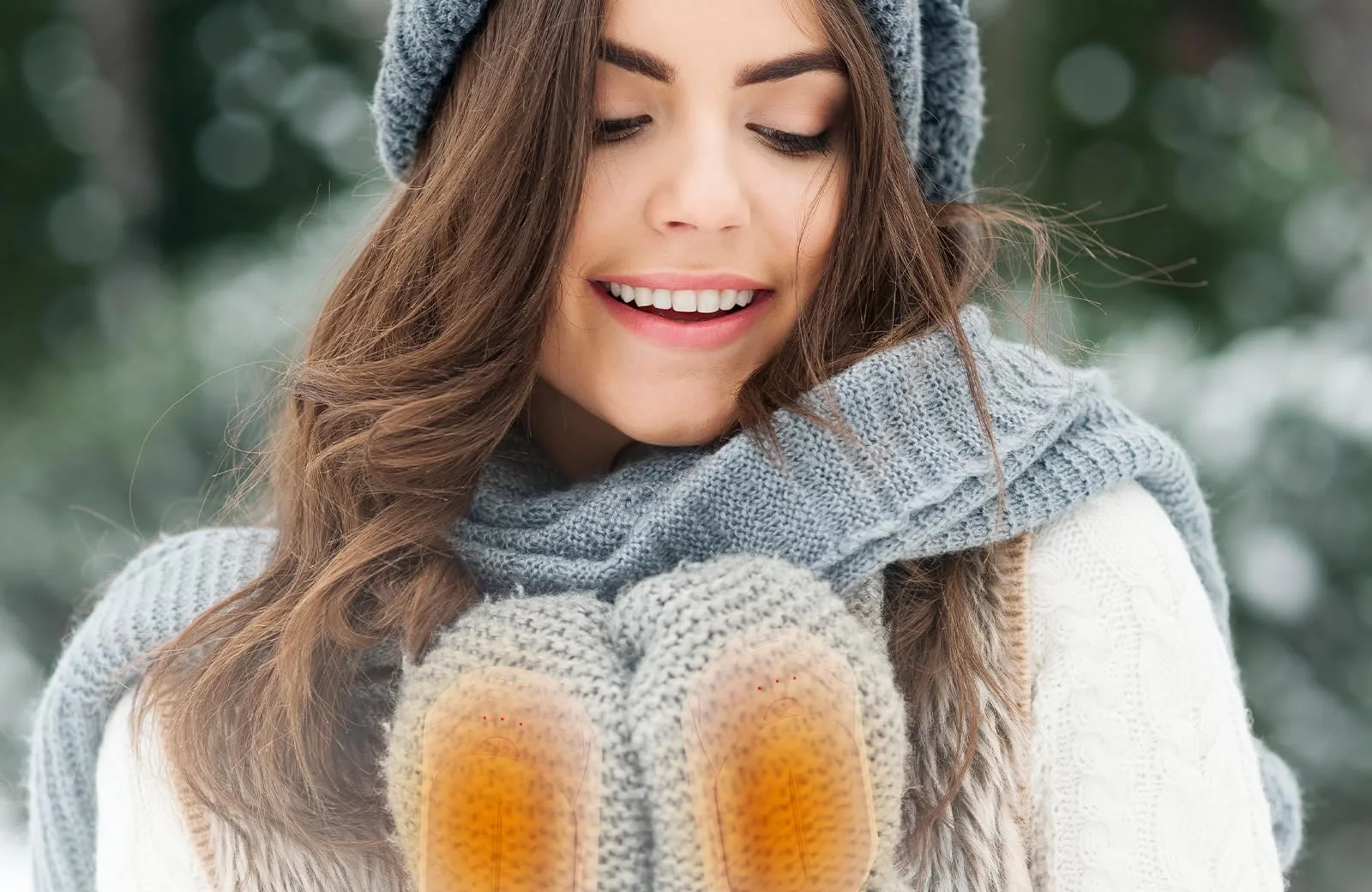 Pink UNIHAND warmers glowing inside knitted mittens